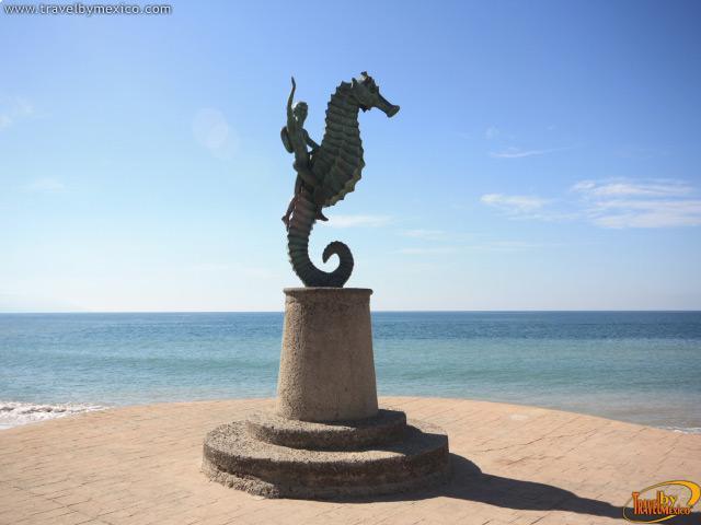 Foto Uma estátua de um cavalo-marinho na frente de um corpo de água –  Imagem de Puerto vallarta